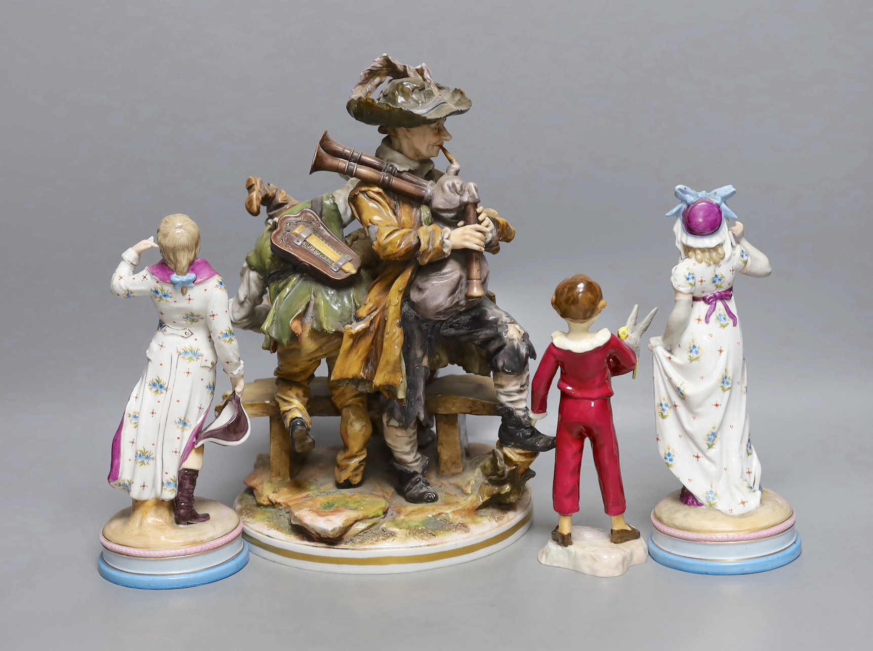 A pair of KPM style porcelain figures of a maiden and a gallant, 22cm, a Capo di Monte figure group, 29cm, and a Royal Worcester figure 'The Parakeet', modelled by F.G. Doughty, no.3087